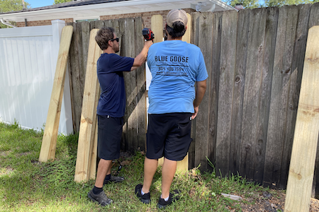 two men repairing a fence