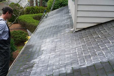 man washing a roof